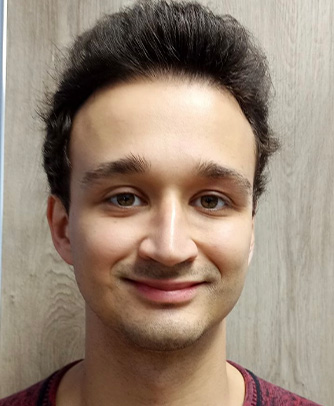 A man with short hair and a beard smiling at the camera.