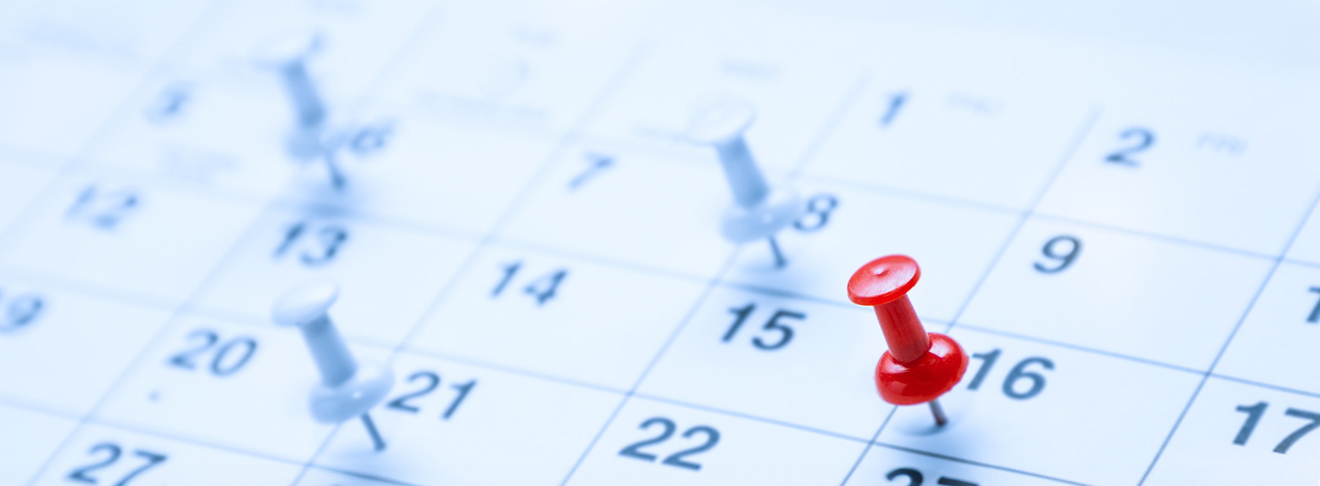 The image shows a calendar with a red push pin placed on an upcoming date, indicating a scheduled event or reminder.