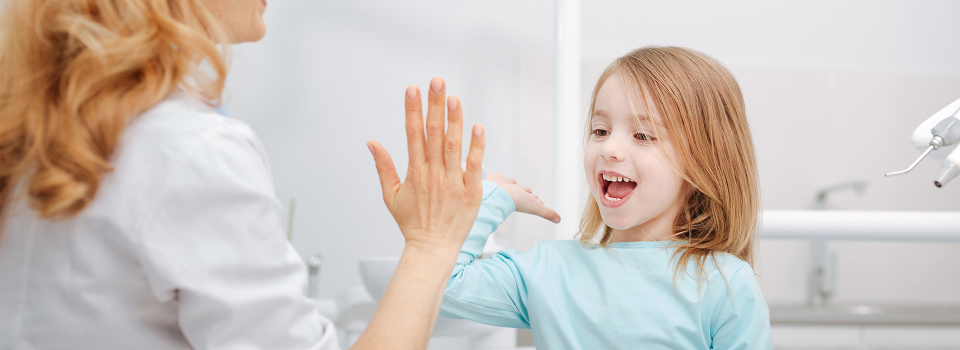 A woman and a child are seen in a bathroom setting  the woman appears to be washing her hands while the child looks on, both with their hands raised towards the camera.